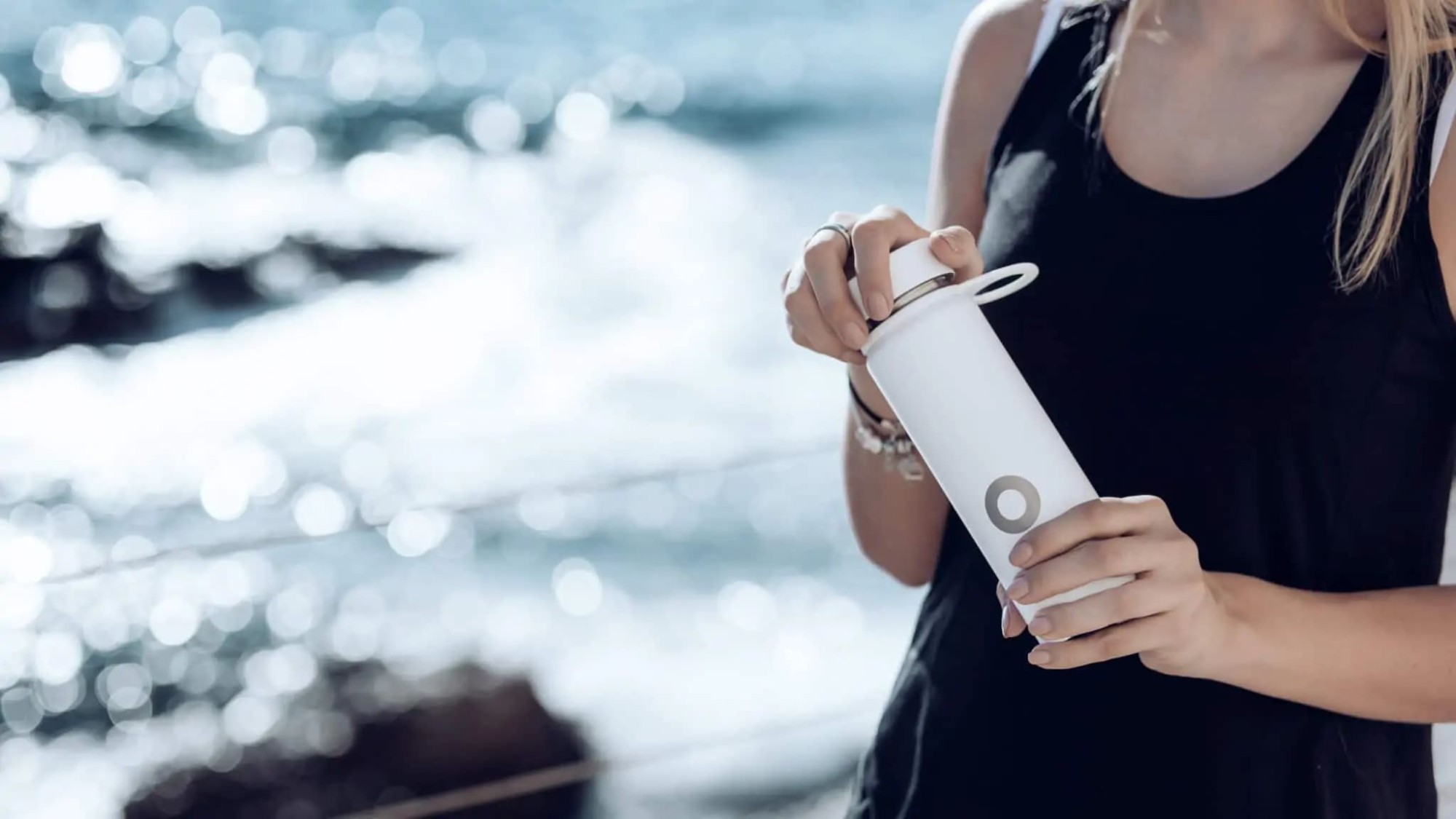 kobieta trzymająca bidon bluewater nad wodą